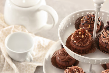 Dessert stand with tasty chocolate cupcakes on table