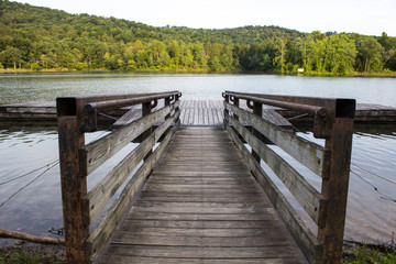 Summer At The Lake. Lake. Wooden dock extends into a lake with the Appalachian Mountains in the...
