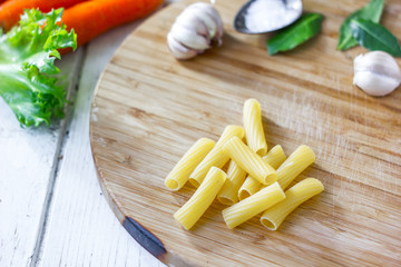 Rigatoni pasta over the wooden kitchen board