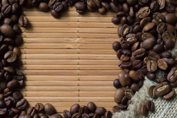 Spilled coffee beans frame over old mat