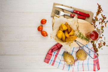 potatoes rustic on a wooden background with tomato sauce with cutlery