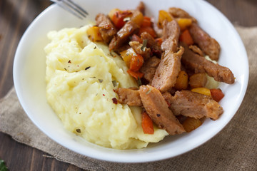 Soy meat with potato puree over kitchen table.