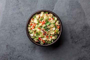 Traditional peruvian quinoa quinua salad in clay bowl, slate gray background