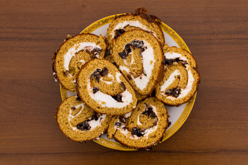 Slices of cake with prunes on a plate on wooden table