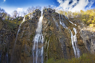 Fototapeta na wymiar Plitvice Lakes with a big waterfall under the blue sky National Park in Croatia