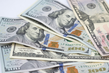 Pile of various US american dollar money bills spread on white background.