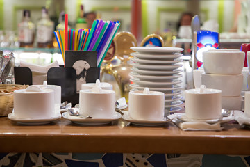 Sugar bowls , plates and colorful straws on the bar