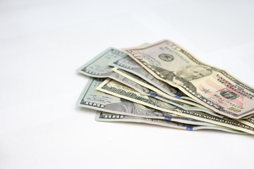 Pile of various US american dollar money bills spread on white background.