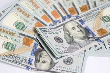 Close up of one hundred US dollar money bills spread on white background.
