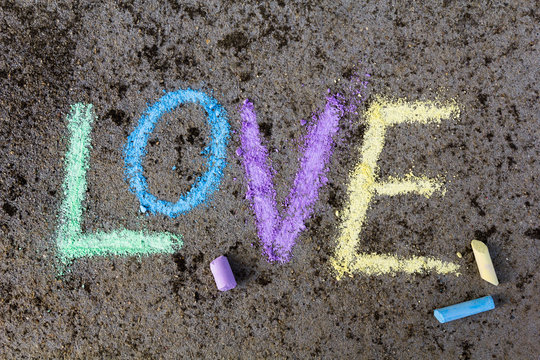 chalk drawing on asphalt: Colorful word LOVE