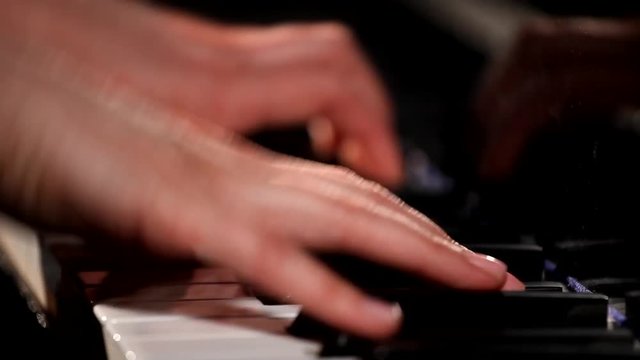 the female hands playing grand piano, closeup   