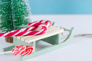 Wooden sled with sweets and Christmas tree.