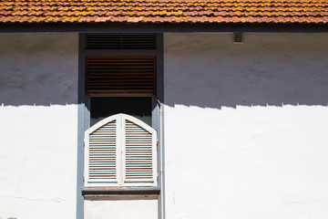 Window with a shutter and shadow of the roof