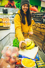woman put cocnut in the cart with products