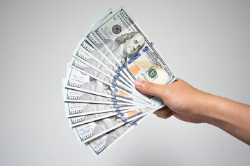 US dollar bills money in hand on white background. Close up businessman hand holding or giving many...