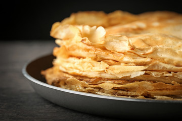 Stack of delicious thin pancakes on plate, close up