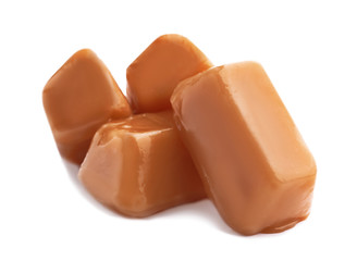Delicious caramel candies on white background