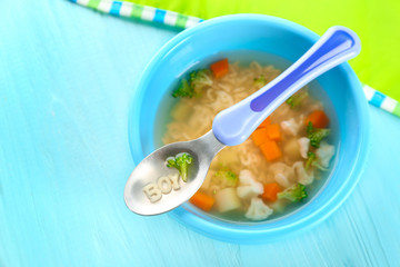 Plate with tasty baby soup on table