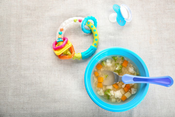 Plate with tasty baby soup on table