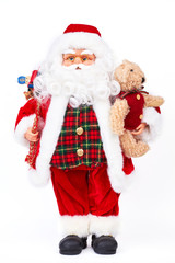Cute Santa Claus doll with gifts. Christmas figurine grandfather frost with toys standing isolated on white background. Happy New Year and merry Christmas.