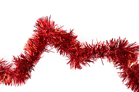 Red tinsel on white background. Line of bright glitter tinsel garland isolated on white background, horizontal image. New Year decorative element.