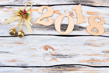 Merry Christmas and happy New Year 2018. Wooden digit 2018 decorated with golden bell, copy space for text, vintage wooden background. Happy New Year concept.
