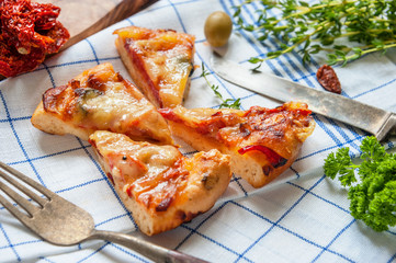 Round sausage pizza Margarita cut into pieces to feed the cloth with sun-dried tomatoes . Selective focus.