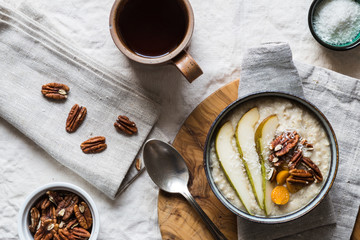 Breakfast porridge bowl with fruit nuts and tea