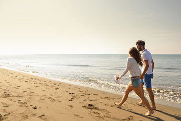 Young happy couple on seashore. Male has beard.