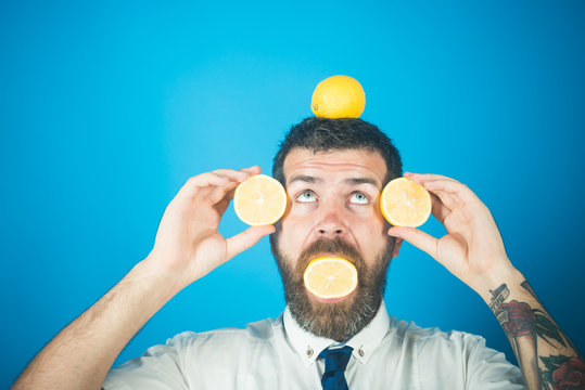 Man with long beard eat lemon.