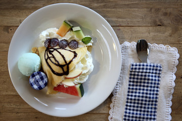 crepe cake with milk ice cream and watermelon melon grapes on wood background