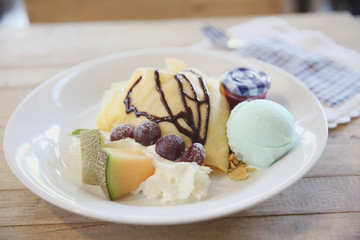 crepe cake with milk ice cream and watermelon melon grapes on wood background
