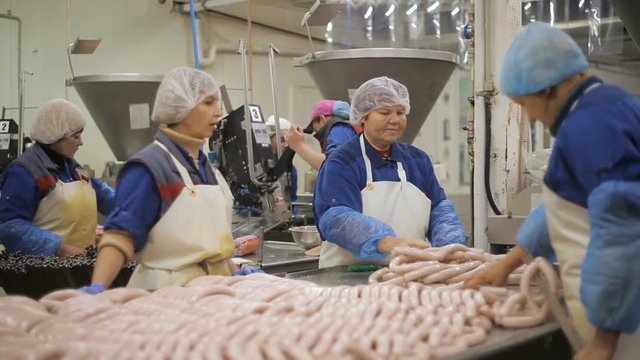 Workers of the meat-packing plant produce sausages