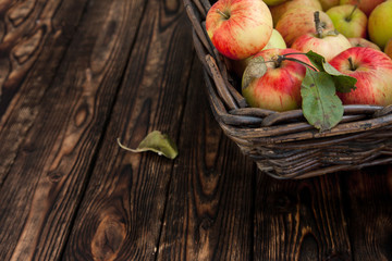 autumn apples in a basket on a wooden background