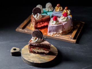 Set of pieces cakes on black background