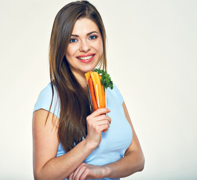 Smiling girl holding glass with carrot.