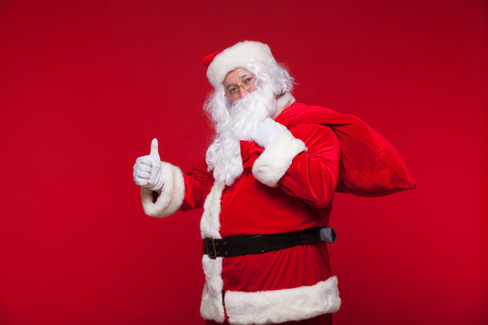 Christmas. santa claus with big bag on shoulder is on red background