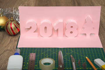 Making  pop-card  in the form of 2018 year. Card and tools  used for its construction on cutting...
