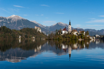 Church, castle and mountains reflecting into the clear, pure waters of Lake Bled in Slovenia