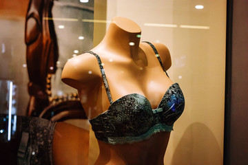 Green bra on female mannequin in a shop window - obrazy, fototapety, plakaty