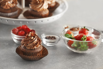 Tasty chocolate cupcake with fresh berries on table