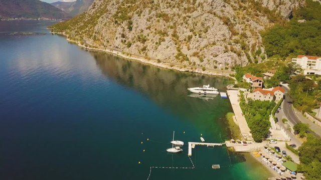 Small quay with moored motor boats. Aerial view of Kotor Bay between mountains