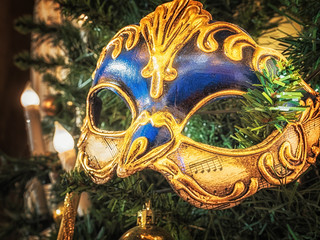Venetian carnival mask on christmas tree. Christmas and New Year's background. Christmas tree, ball, candle, mask, Christmas decorations