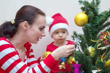 Mother with baby decorating Christmas tree