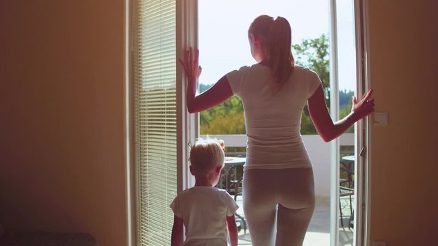 Mother and son open the window rural house
