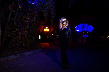 Fototapeta na wymiar Halloween skull make up girl wear in black at night street of city.