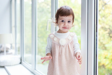 Baby girl smiles in a room near the window