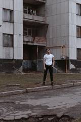 Fototapeta premium A handsome and stylish guy walks the old abandoned streets