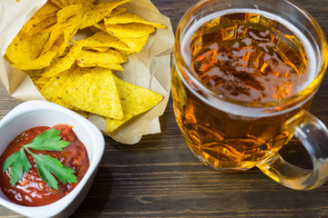 Nachos corn chips with classic tomato salsa. Fresh cold beer is perfect with savory snacks.