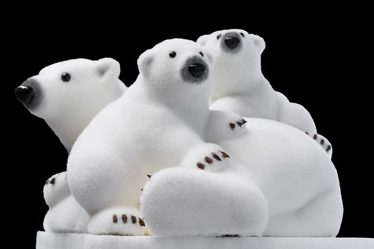 Christmas and New Year decorations: figurines of a white polar bear with cubs. Isolated, black background.
